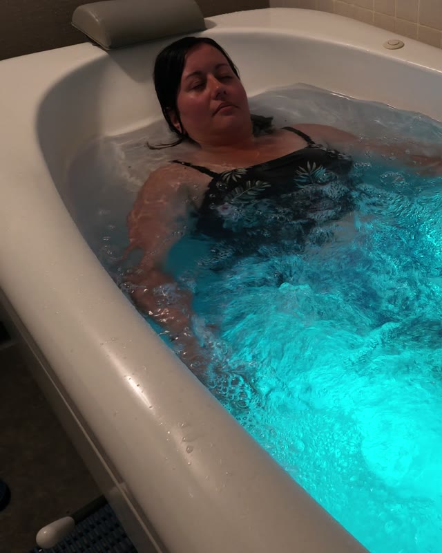 Une personne d&eacute;tendue dans un bain bouillonnant &eacute;clair&eacute;